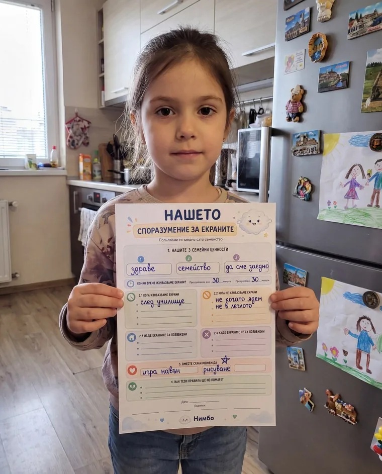 Дете показва попълненото „Нашето споразумение за екраните“